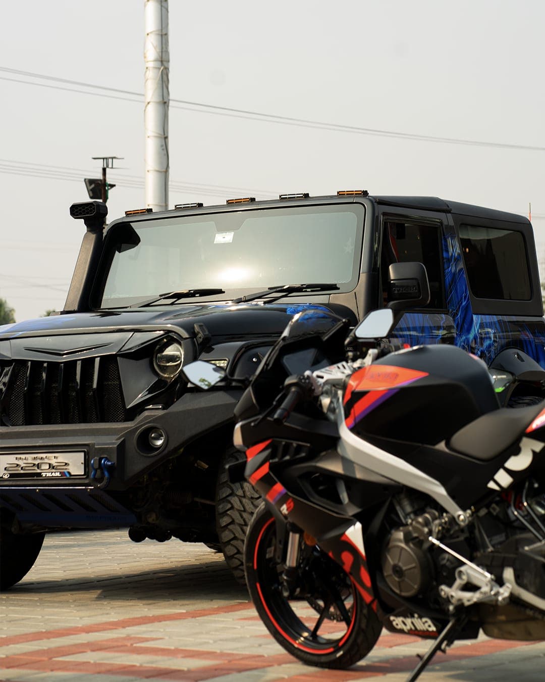 Black SUV and sportbike on display