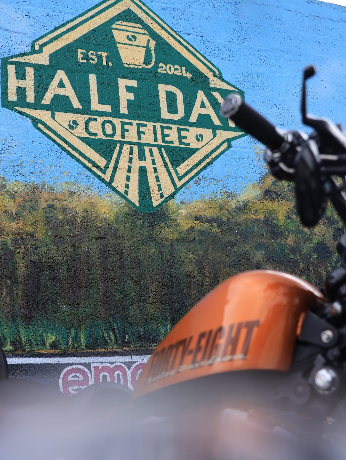 Orange motorcycle by the HalfDay sign
